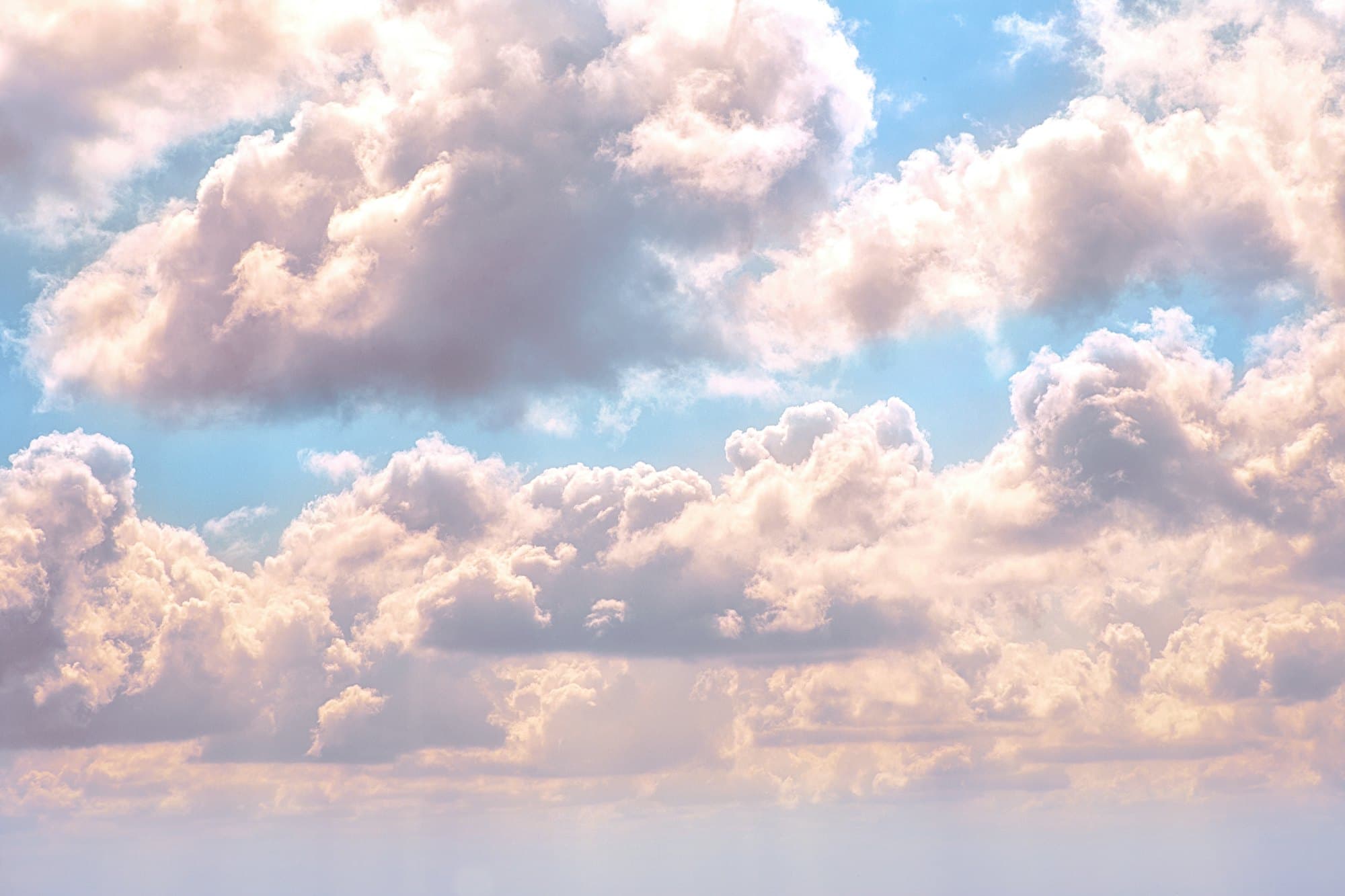 Towering cumulus catching gold and pink light at the end of the day.